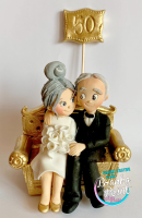 Zlatna-svadba-par-na-zlatnom-trosedu-beli-buket